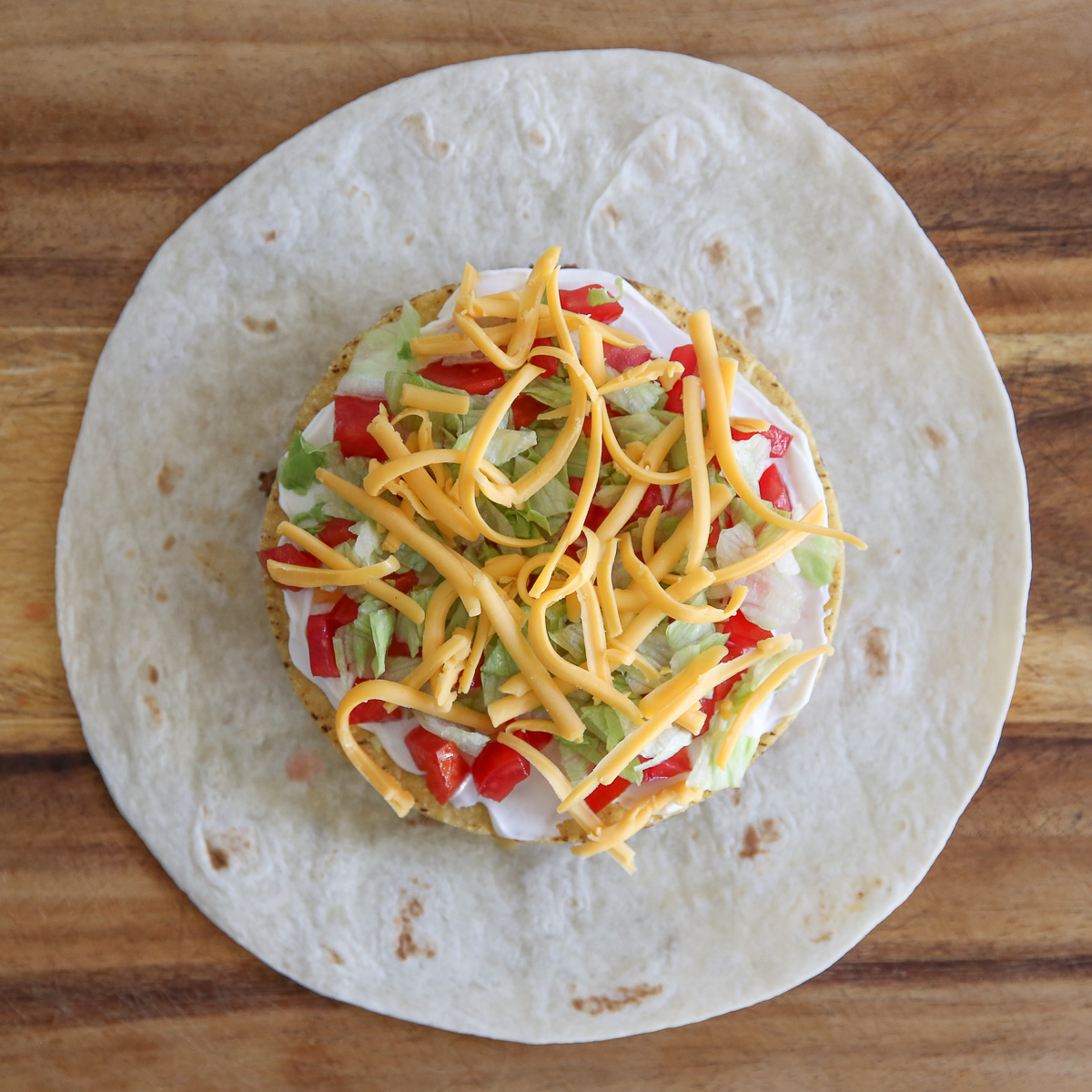 cheese, lettuce, and tomatoes on a crunch wrap supreme