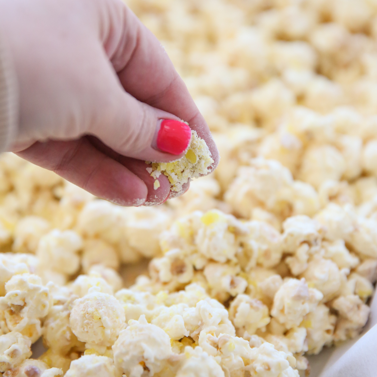 sprinkling crushed lemon candy on popcorn
