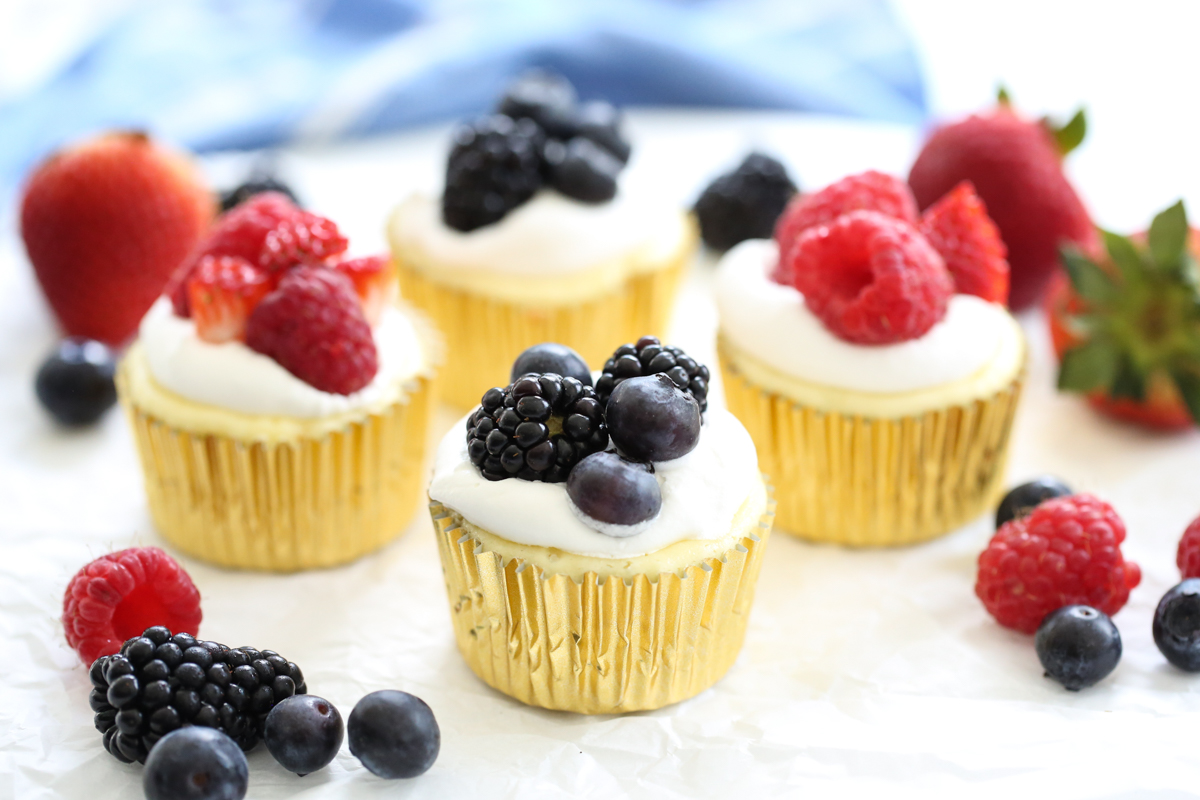 fruit topped mini cheesecakes on a platter