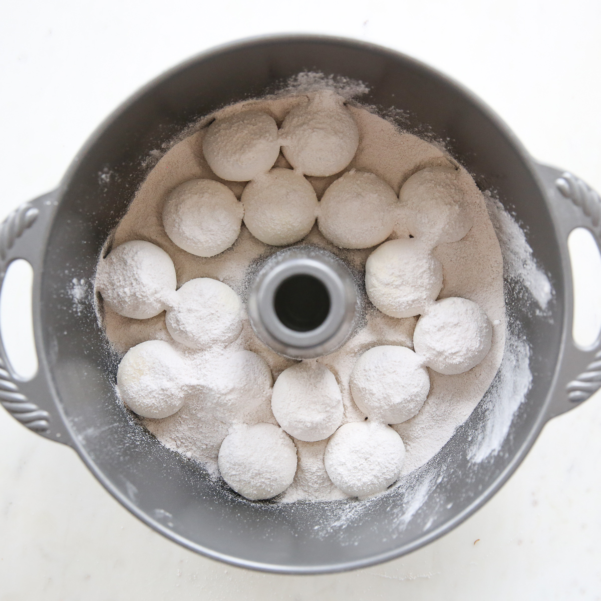 assembling overnight caramel rolls in a bundt pan