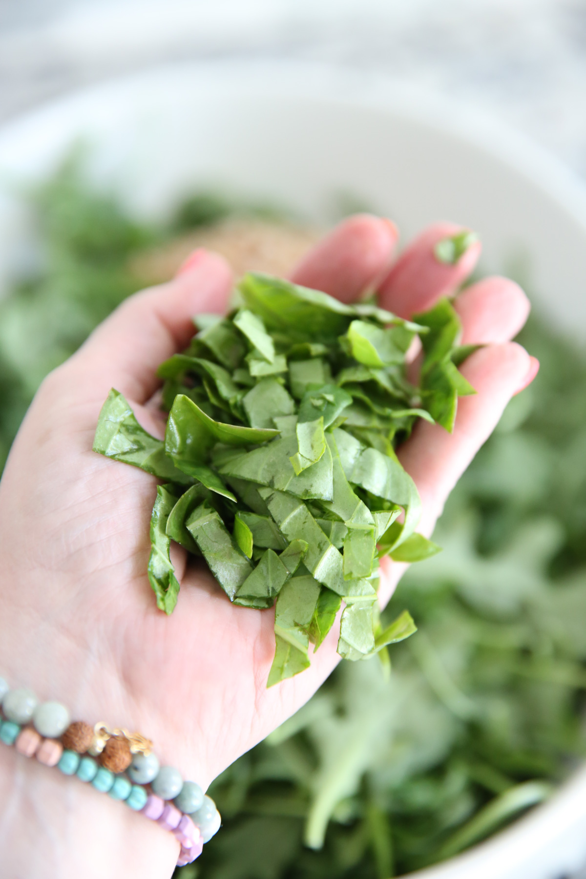 holding a handful of chopped basil