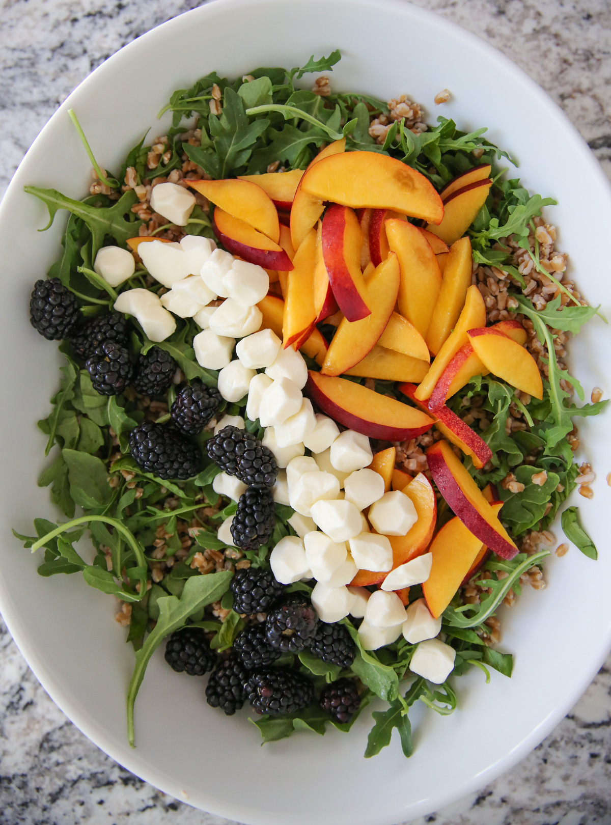 Peach Arugula Salad in a white bowl