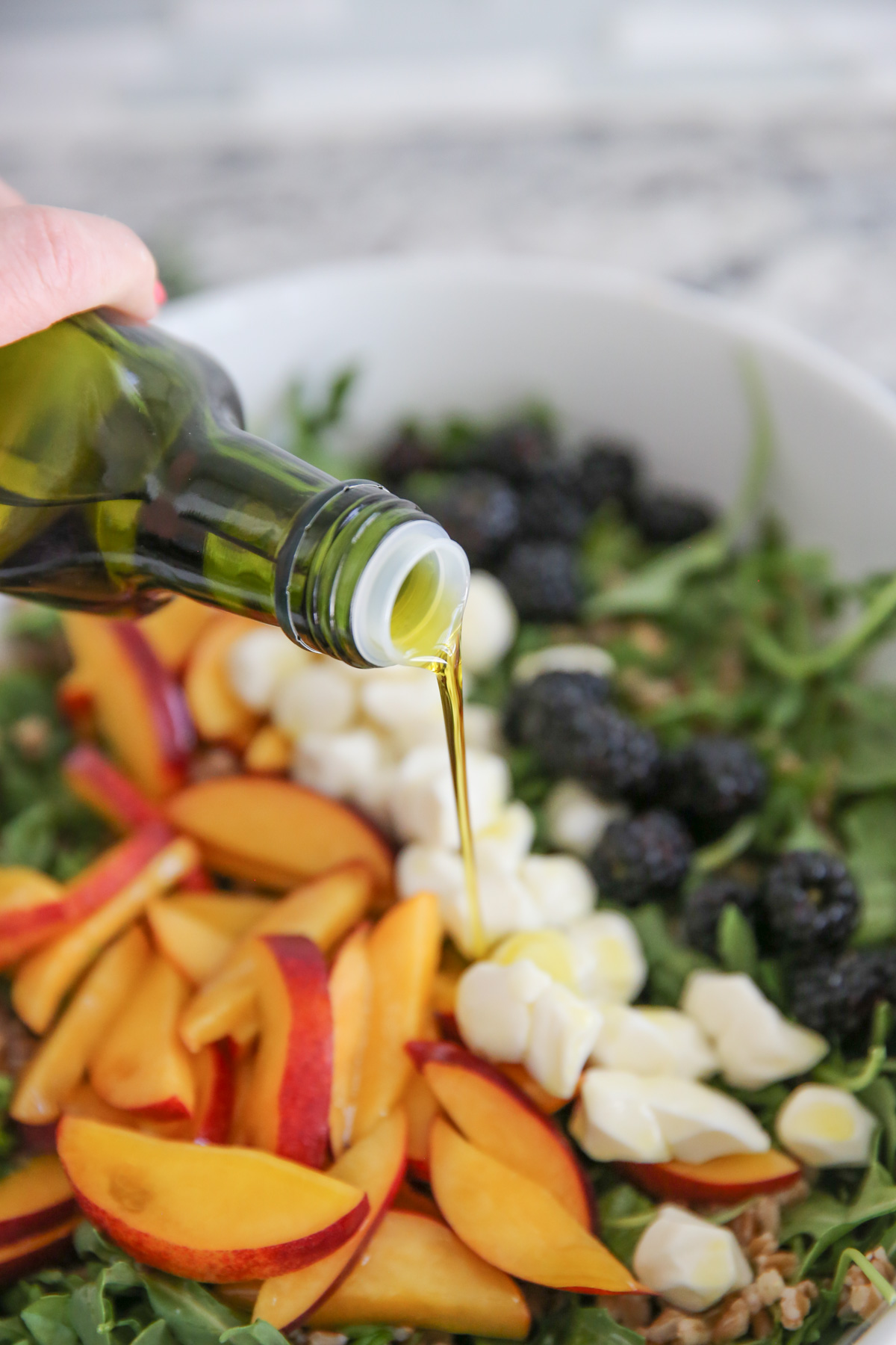 pouring olive oil over a salad