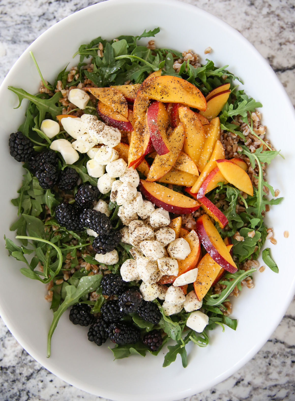 Peach Arugula Salad in a white bowl