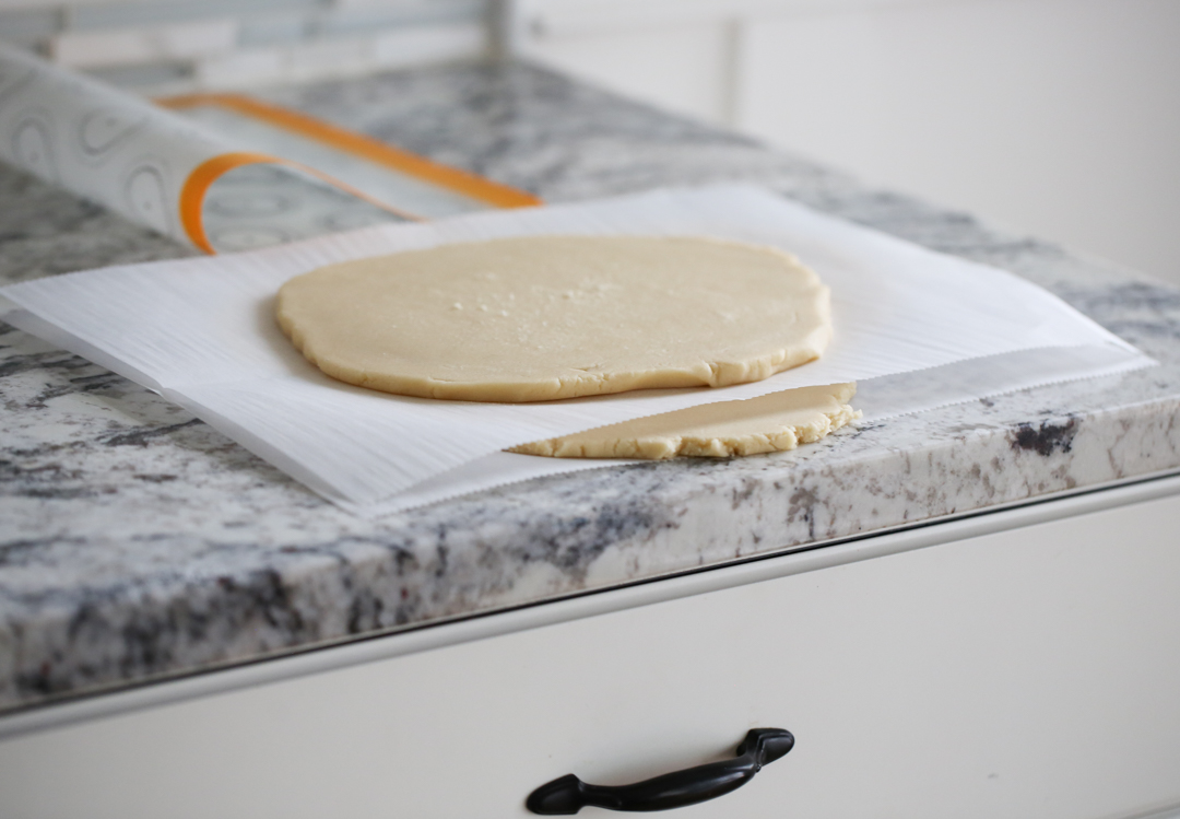 Sugar cookie dough rolled into slabs and stacked with parchment paper.