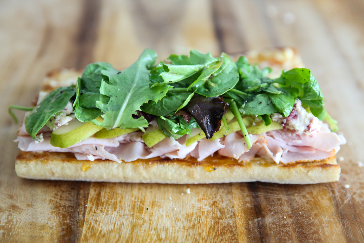 building a turkey sandwich on a cutting board