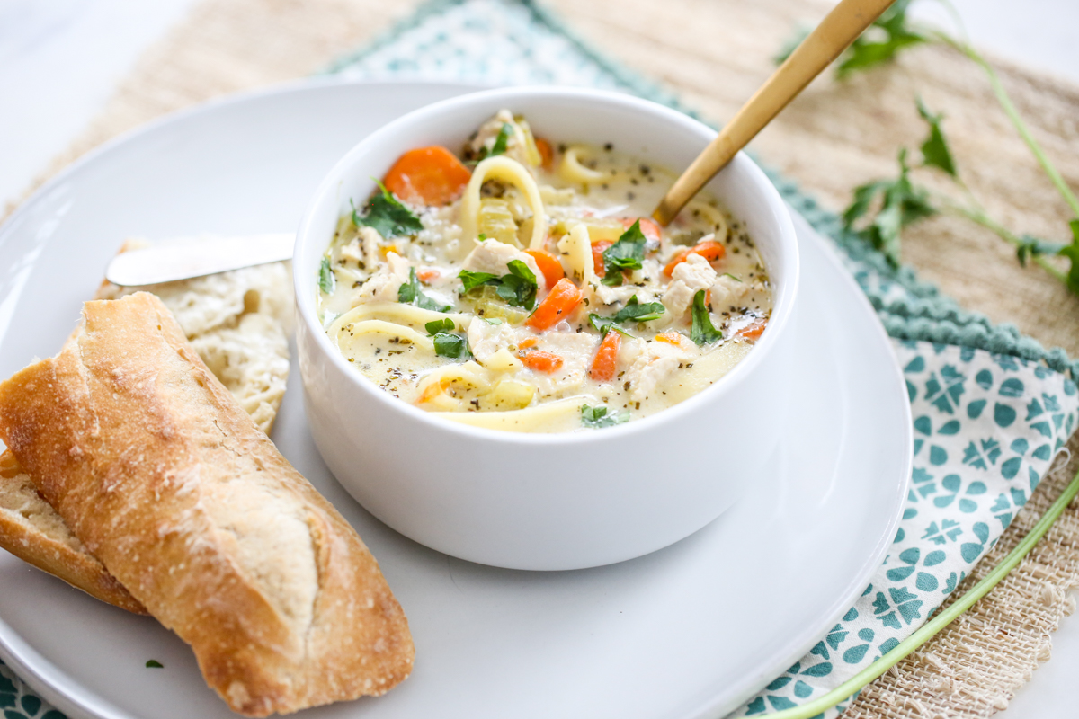 Creamy Chicken Soup in a bowl with bread on the side