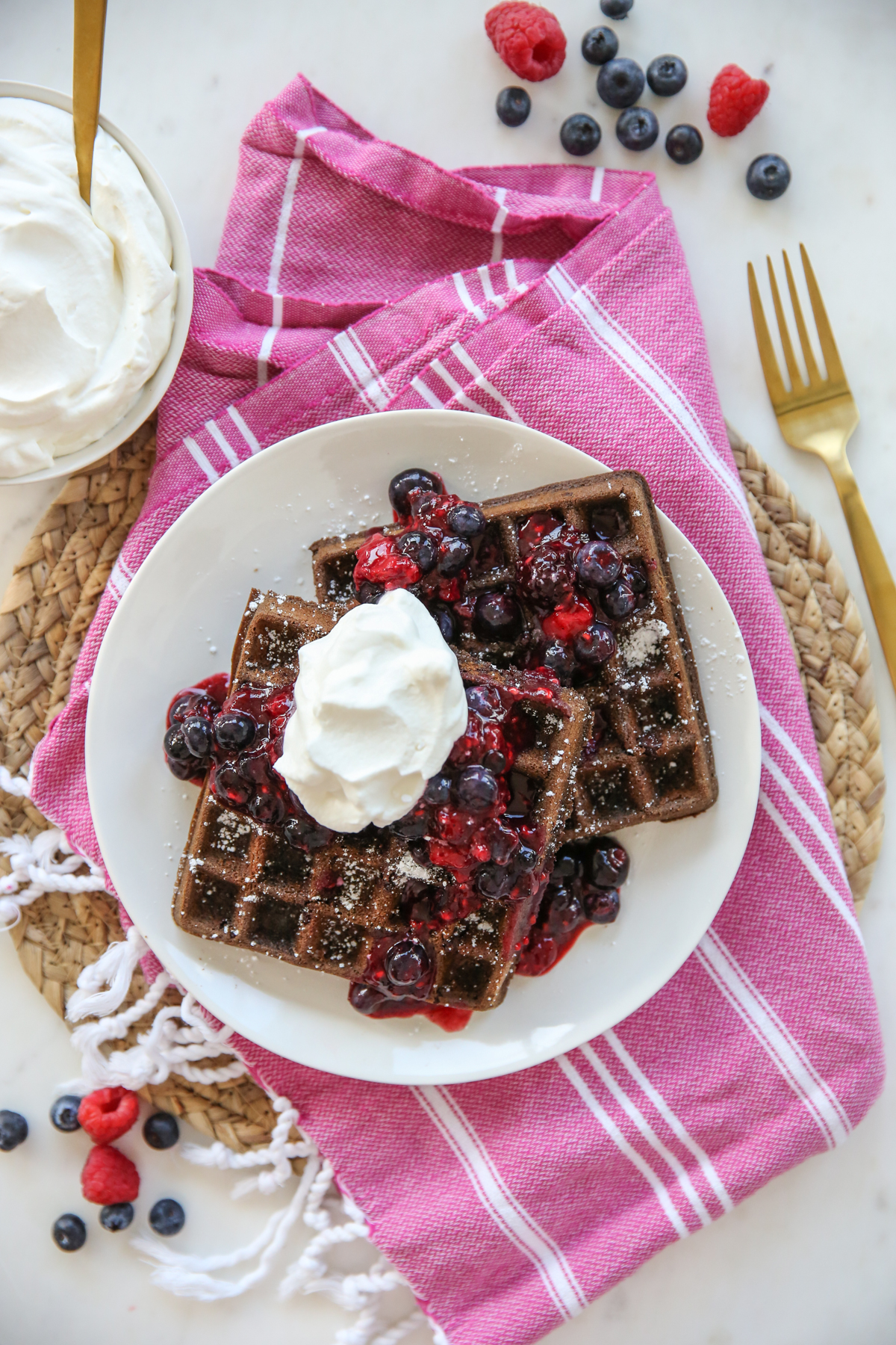 Chocolate Waffles with whipped cream and berries on a plate