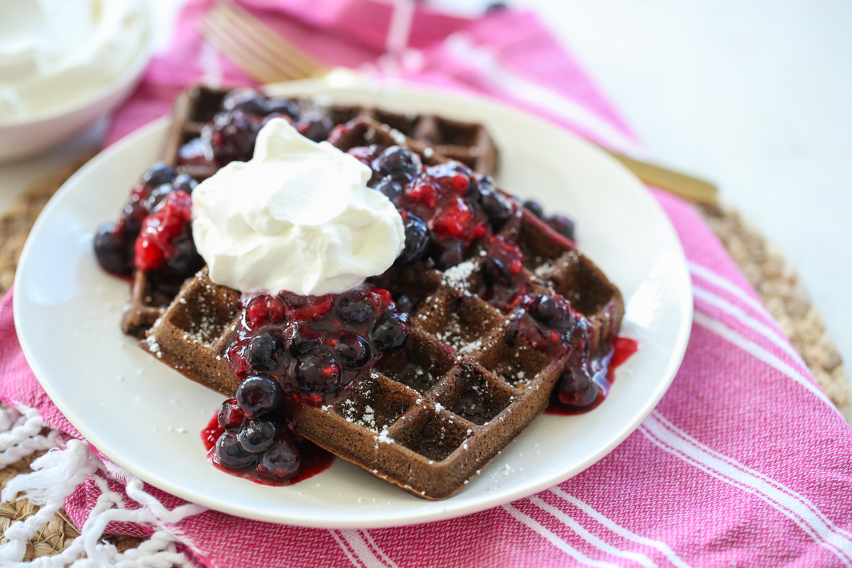 Chocolate Waffles with whipped cream and berries on a plate